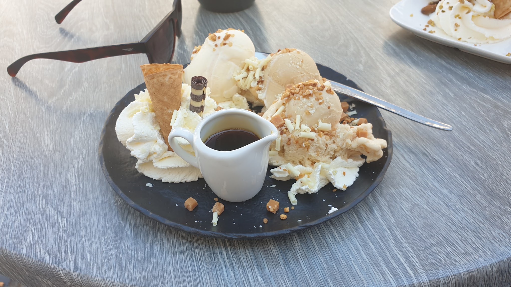Koffie met een dessertbord vol ijs, slagroom en karamel
